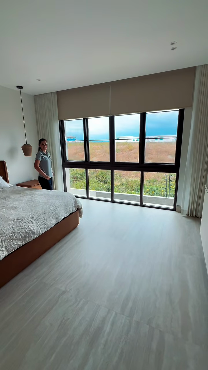 Cortinas Doble Onda y enrollable blackout junto a un ventanal