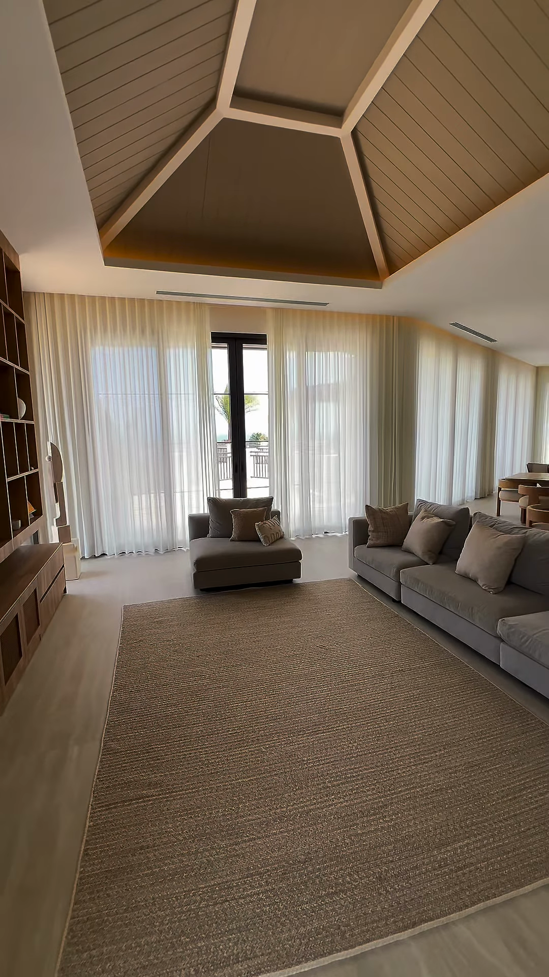 Cortinas claras en un salón con ventanales